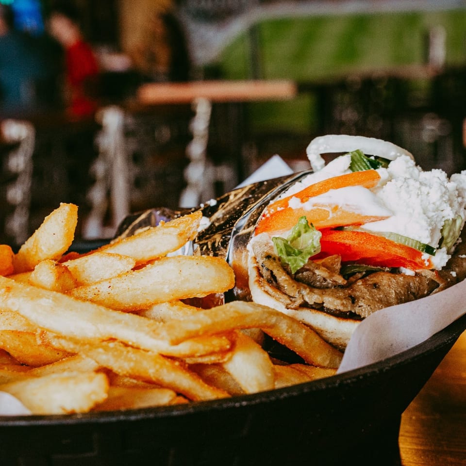 Tito's Lounge gyro with fries, topped with feta, tomatoes, onions, and lettuce.